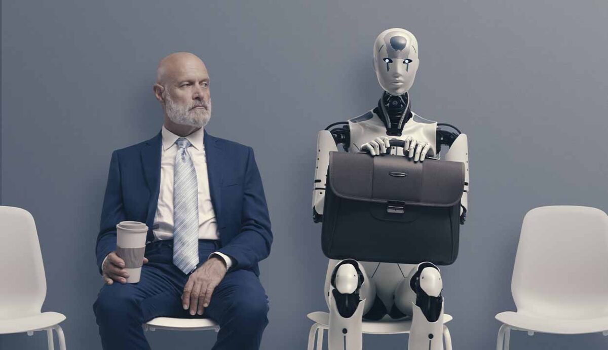 Homem de terno e gravata sentado ao lado de um robô com inteligência artificial