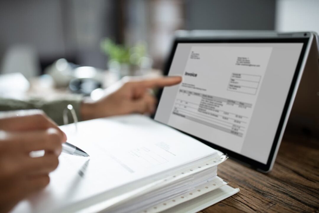 mãos em um tablet com documentos