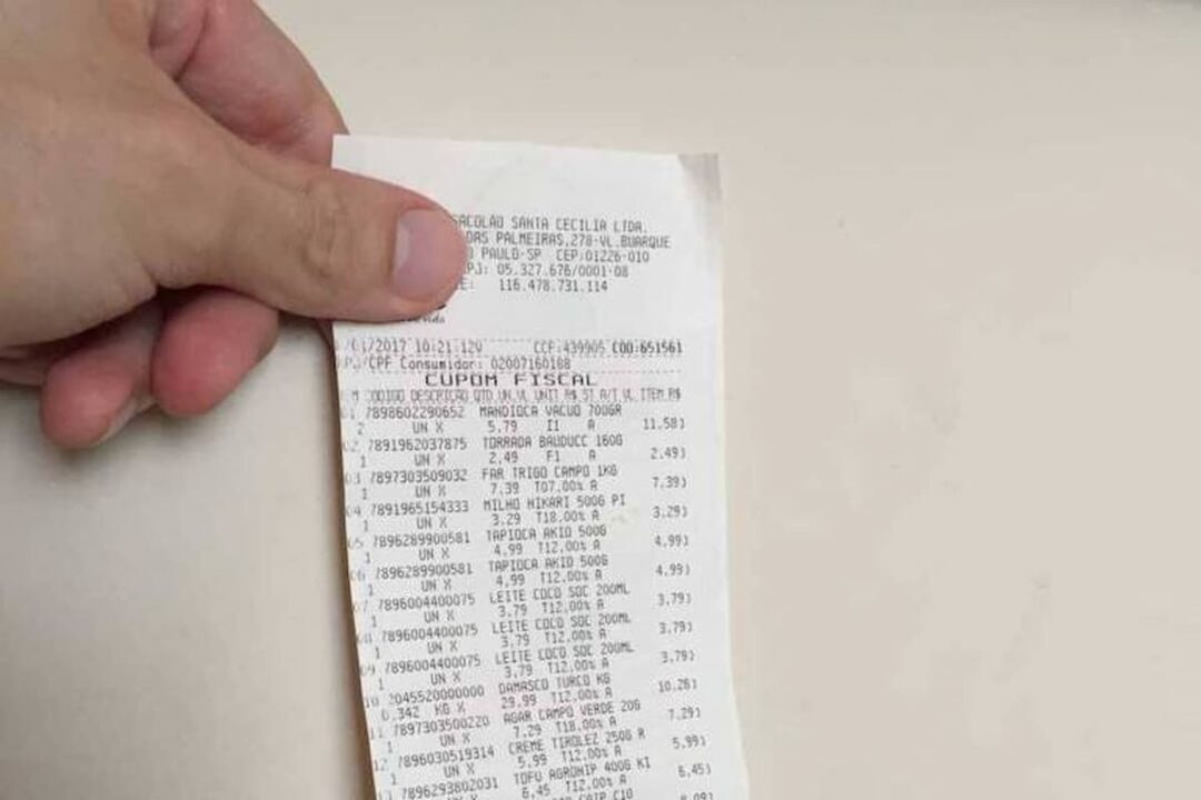 Imagem de pessoa segurando a nota fiscal paulista