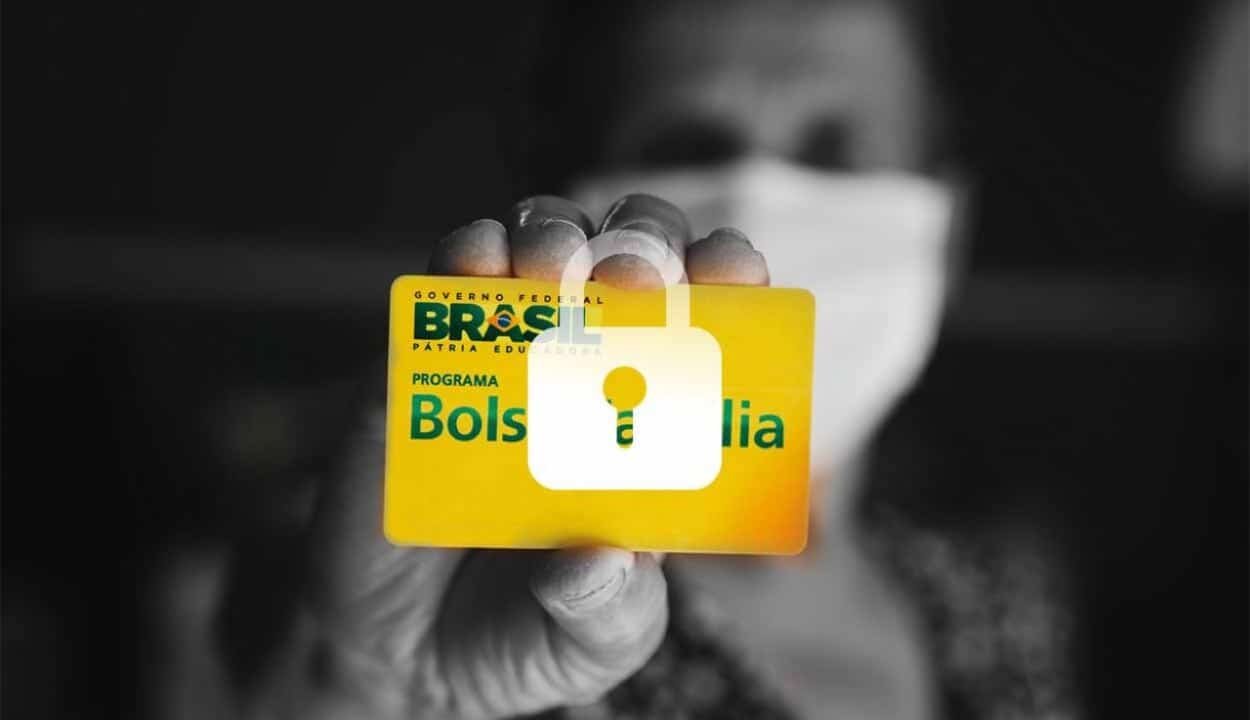 pessoa segurando um cartão do bolsa família com uma ilustração em cima de um cadeado indicando que o benefício está bloqueado