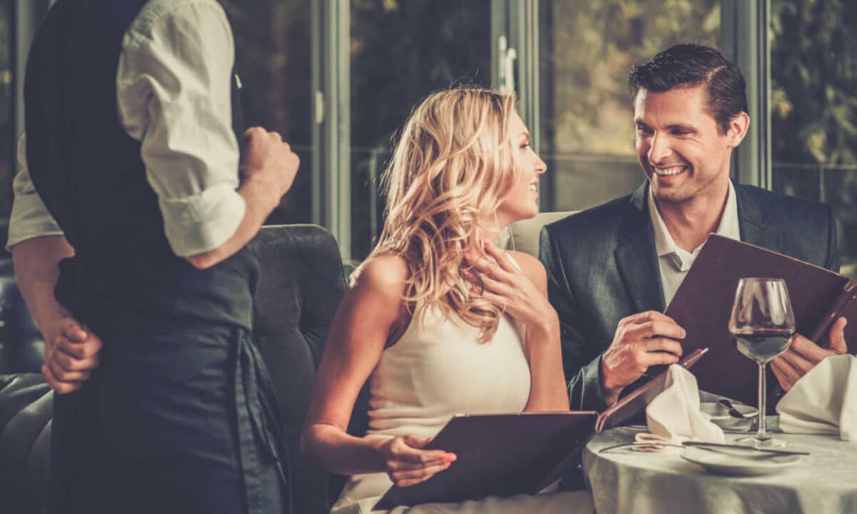 Casal sorrindo enquanto faz seu pedido em um restaurante