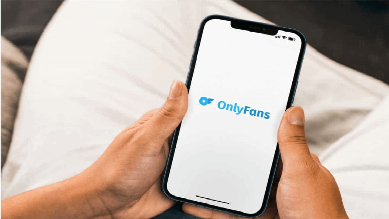 Pessoa segurando celular com aplicativo OnlyFans aberto
