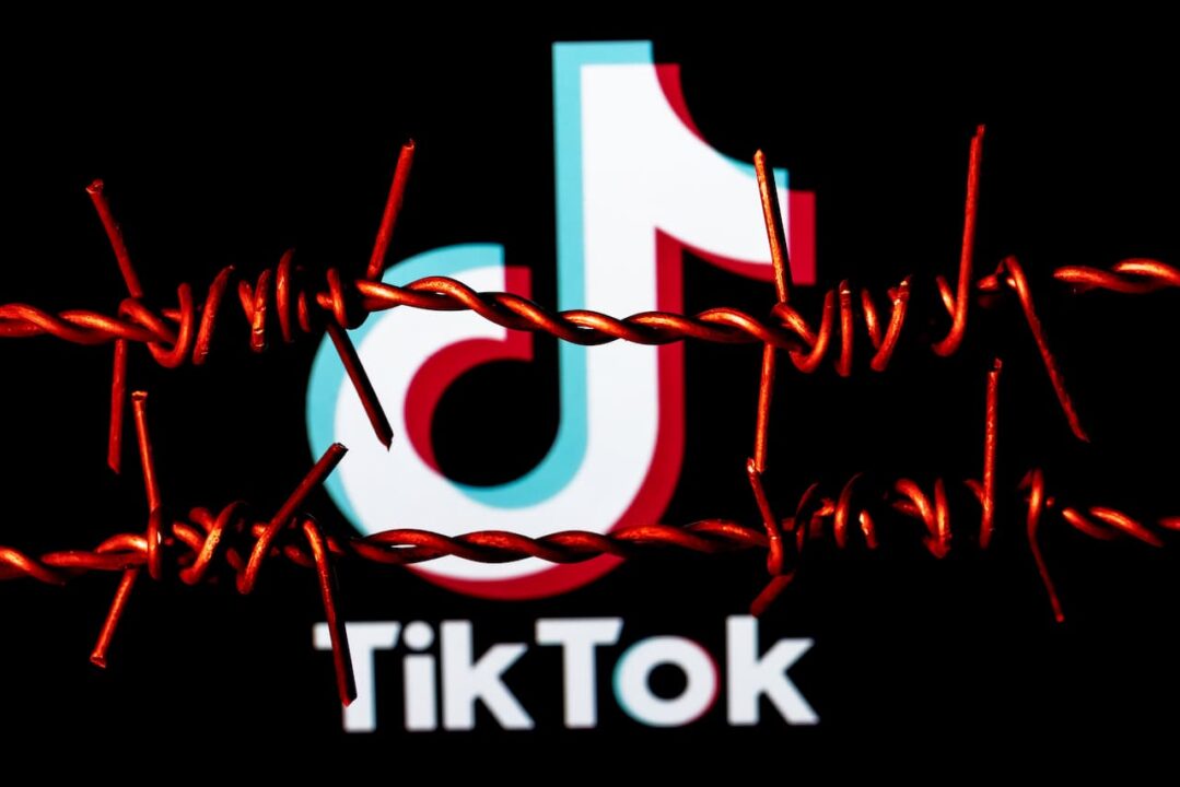 logo do aplicativo TikTok por trás de uma ilustração de arame farpado