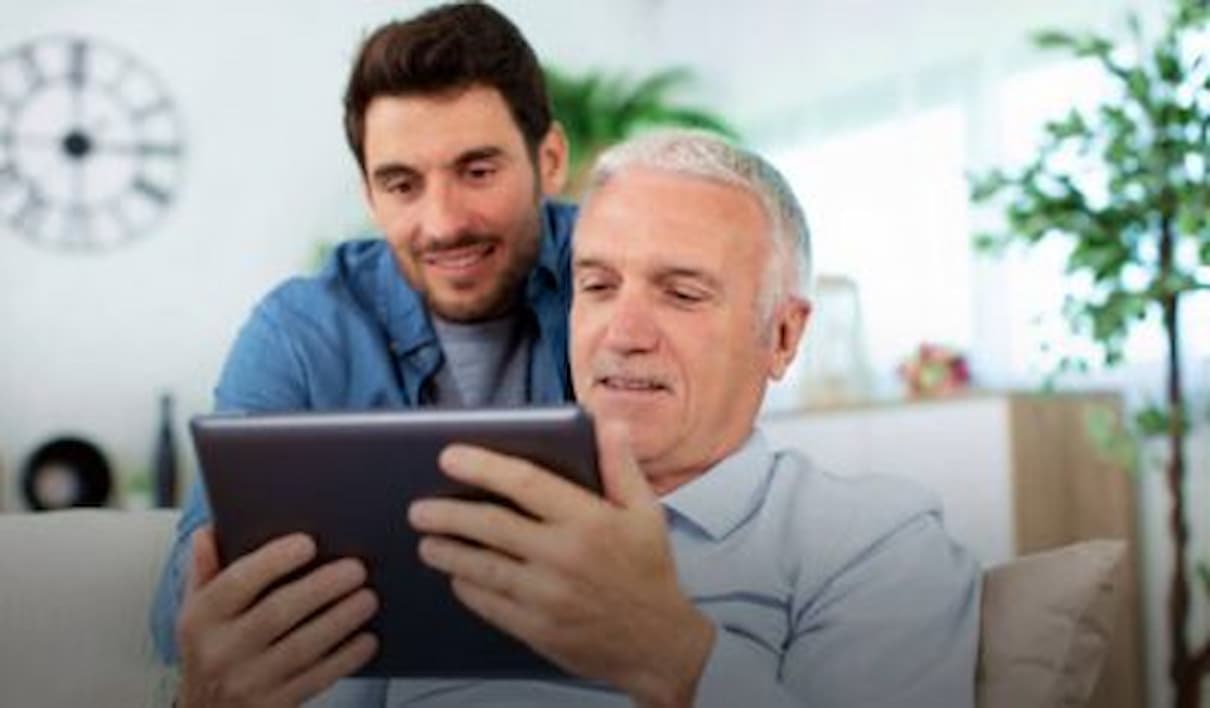 Pai e filho olhando para um tablet juntos