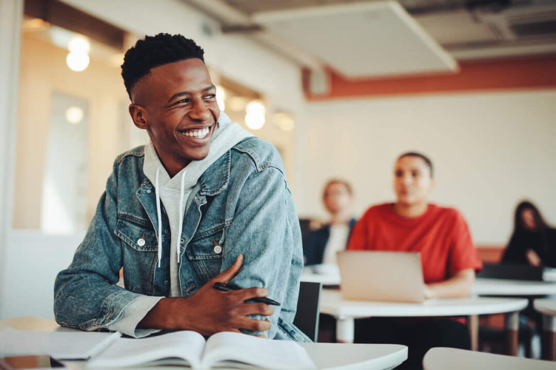 Estudante em sala de aula sorri