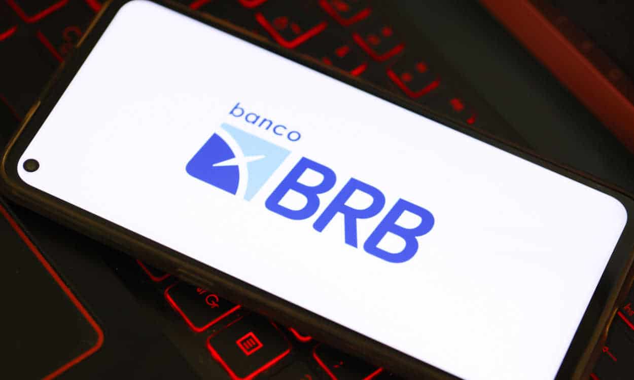 Celular em cima de um teclado de computador com logo do BRB na tela