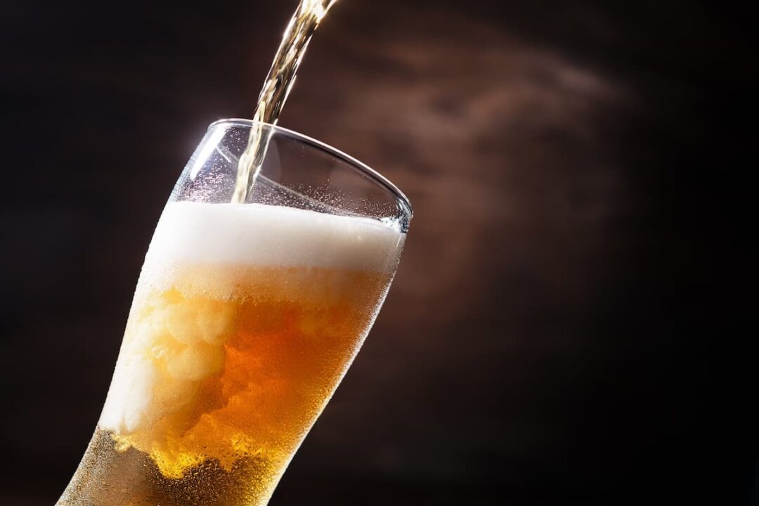 um copo sendo preenchido com cerveja