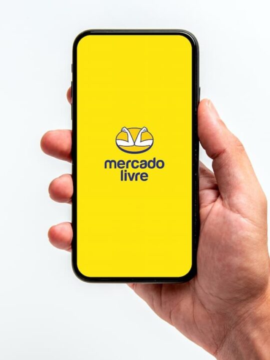 mão segurando celular com logo do Mercado Livre aberto na tela