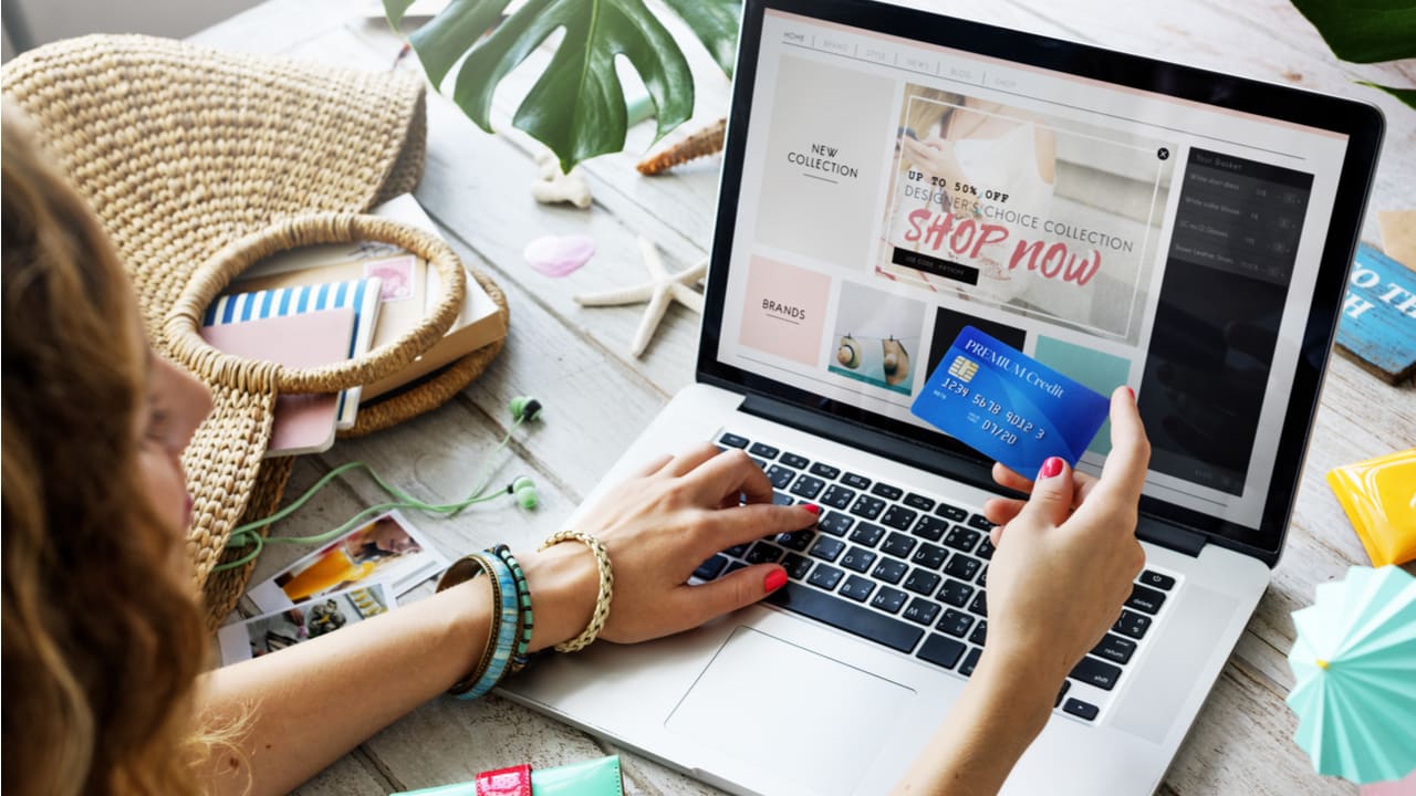 mulher usando um cartão e fazendo compras pela internet em notebook