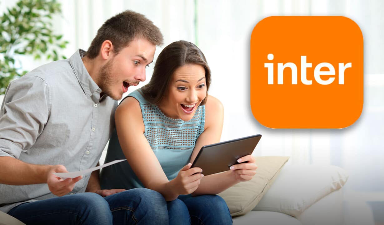Um casal com tablet nas mãos com expressões de supresa. Ao lado da imagem, logo do banco Inter.