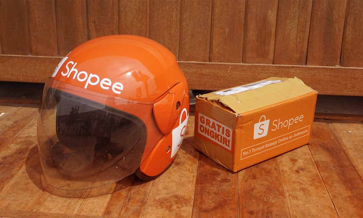 Capacete ao lado de caixa da Shopee.