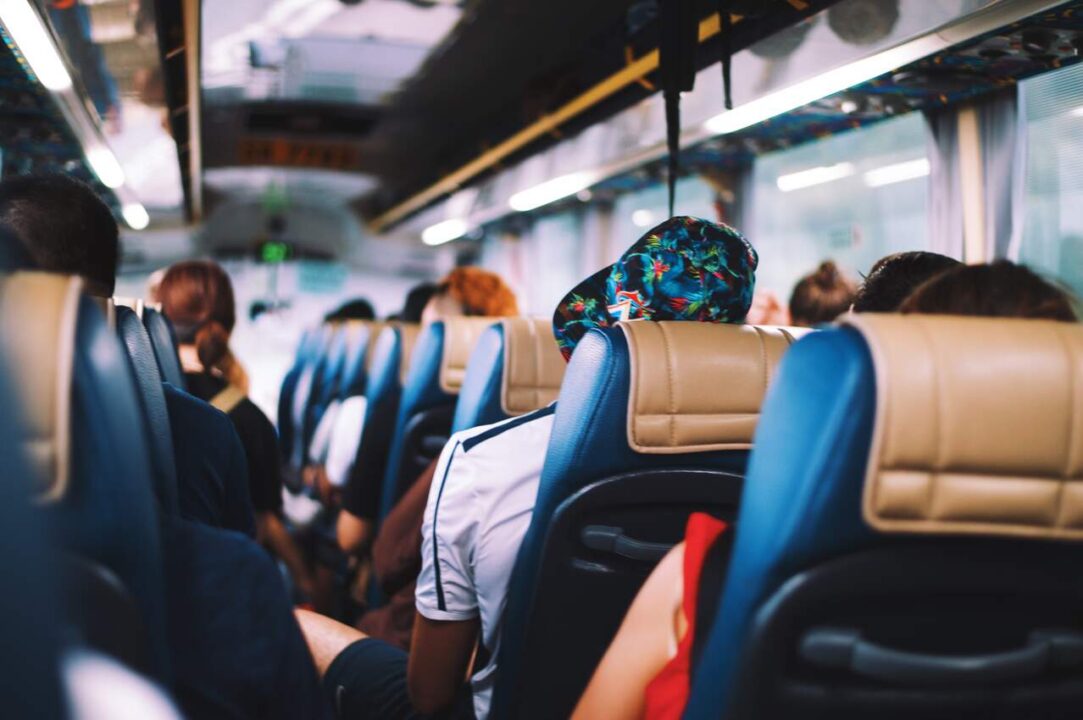 Poltronas ocupadas por passageiros em ônibus.
