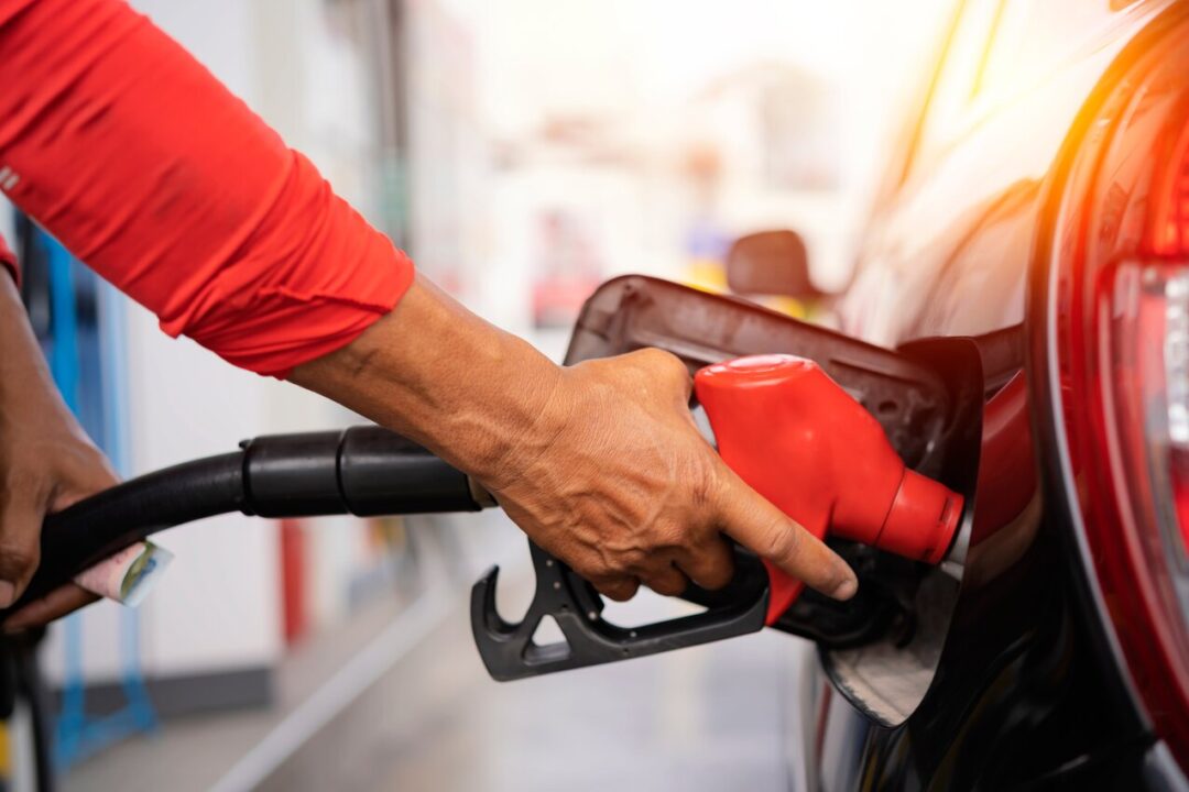 Na imagem, mão abastecendo o carro com gasolina.