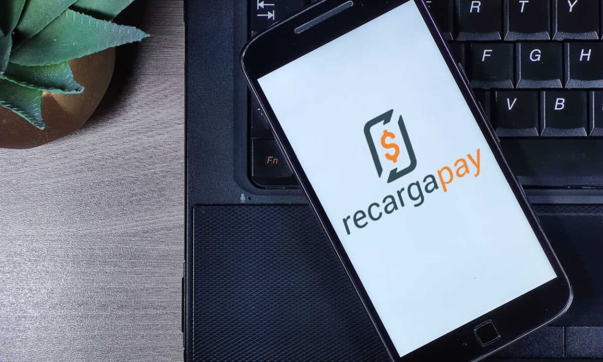 Celular com a logo da RecargaPay em cima de um notebook