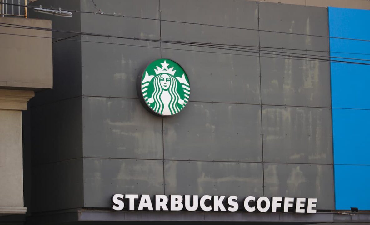Fachada da cafeteria Starbucks e o logo da empresa.