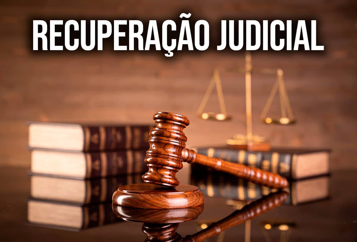 Imagem de um martelo de juiz com diversos livros ao lado, na parte superior está escrito "Recuperação judicial"