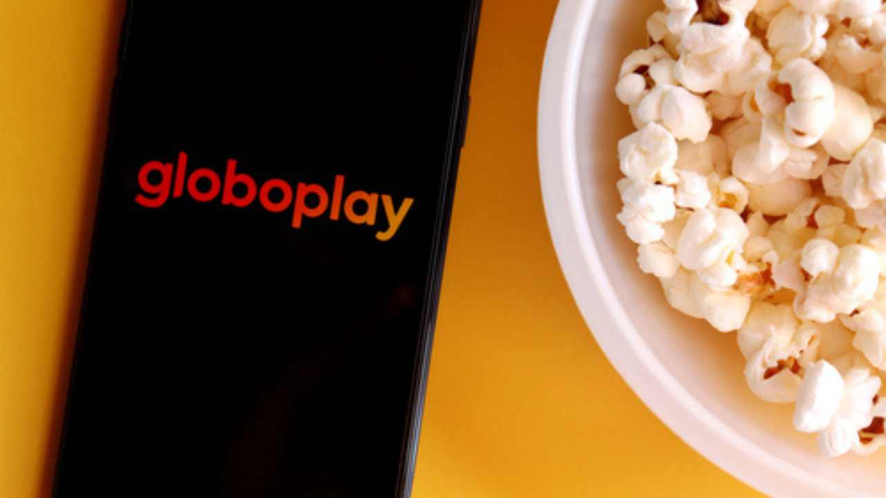 aplicativo globoplay em um celular e pipoca ao lado