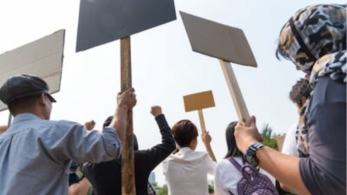Foto de trabalhadores segurando cartazes em protesto