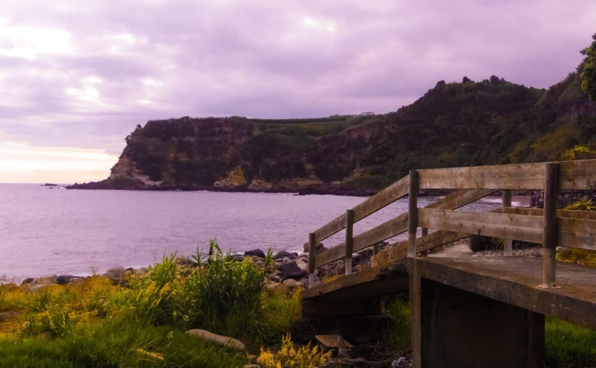 Uma ilha na Irlanda. Imagem de um lago, um horizonte montanhoso, uma escada de madeira e vegetação