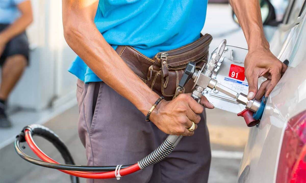 imagem de homem enchendo tanque de carro com bomba de combustível GNV