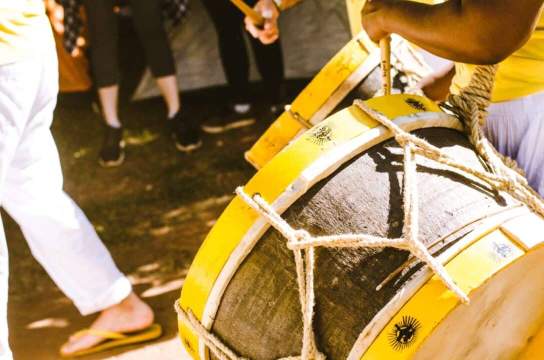 nação de maracatu com músicos tocando alfaia em cortejo