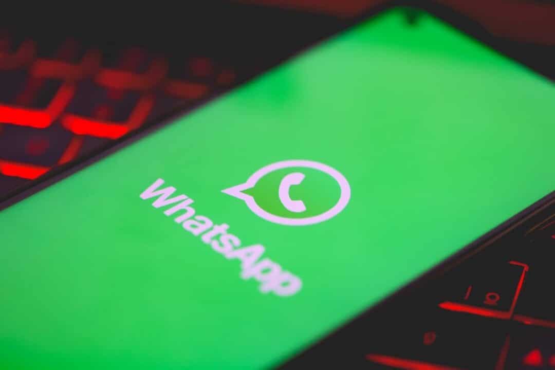Aplicativo do WhatsApp em celular sobre teclado de notebook