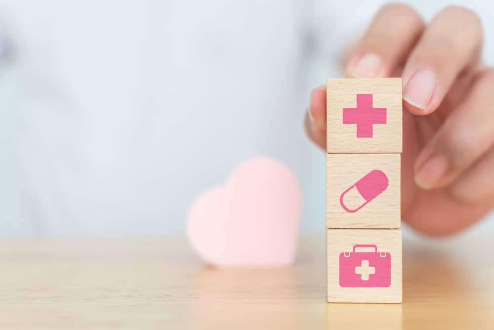 pessoa empilhando simbolos de saúde, plano médico, primeiros socorros