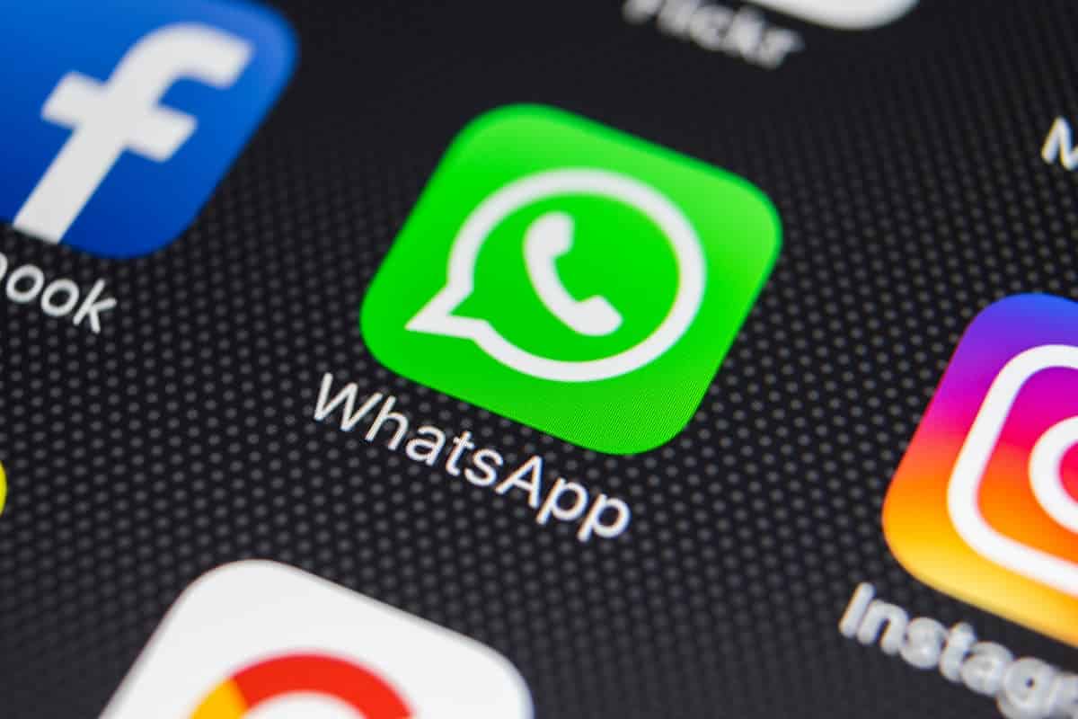Aplicativo do WhatsApp em celular ao lado dos ícones do Facebook e Instagram