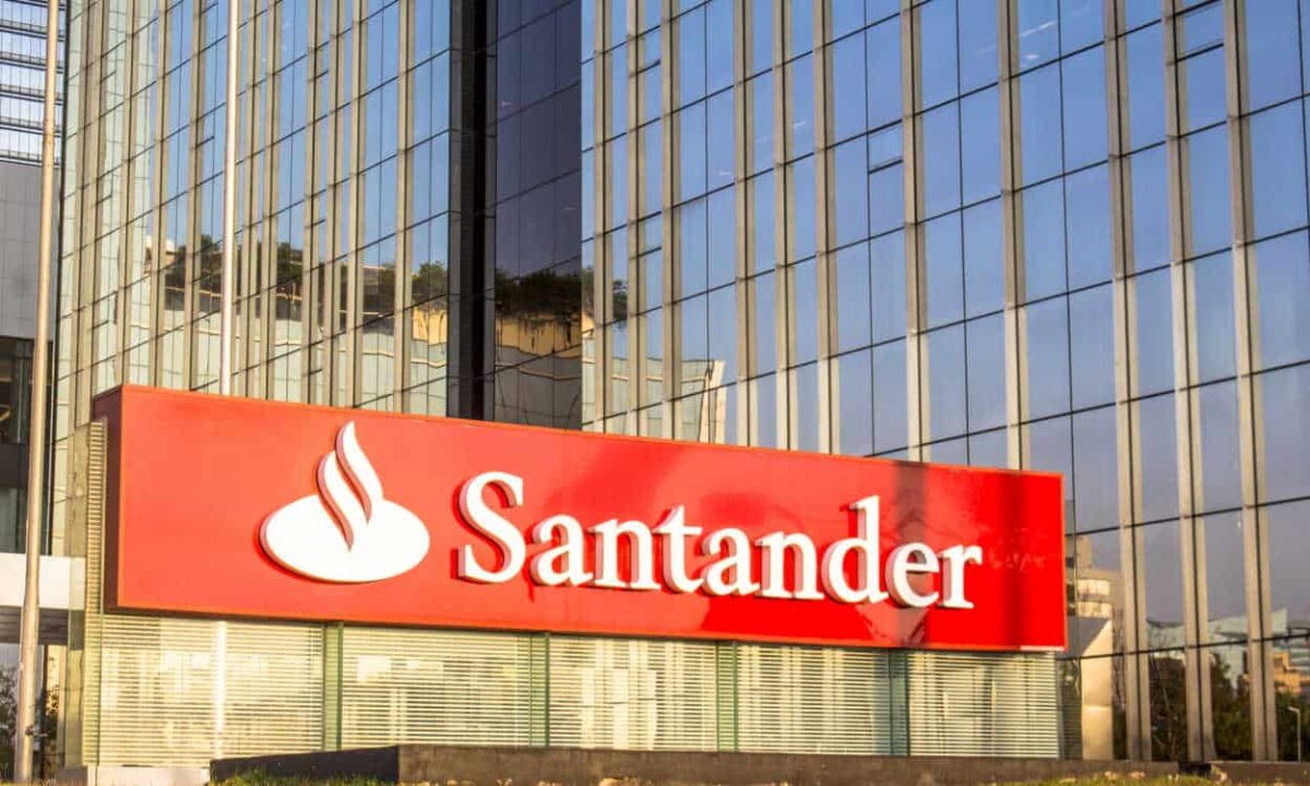 Letreiro do banco Santander na frente de prédio da instituição financeira.