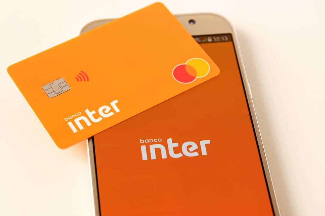 Aplicativo do banco Inter em celular com cartão da instituição sobre o aparelho.