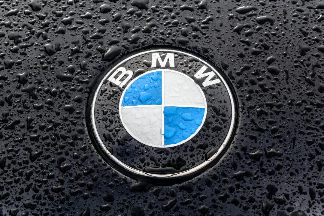 Logotipo BMW sobre capô preto com gotículas de água. multa