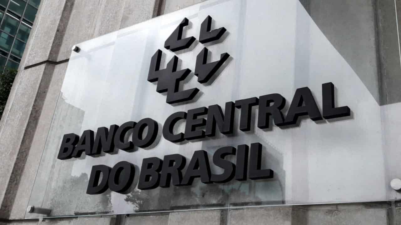 Placa de vidro com a logo e nome do Banco Central em parede de prédio. Representando o pronunciamento dos bancos sobre o rotativo do cartão.