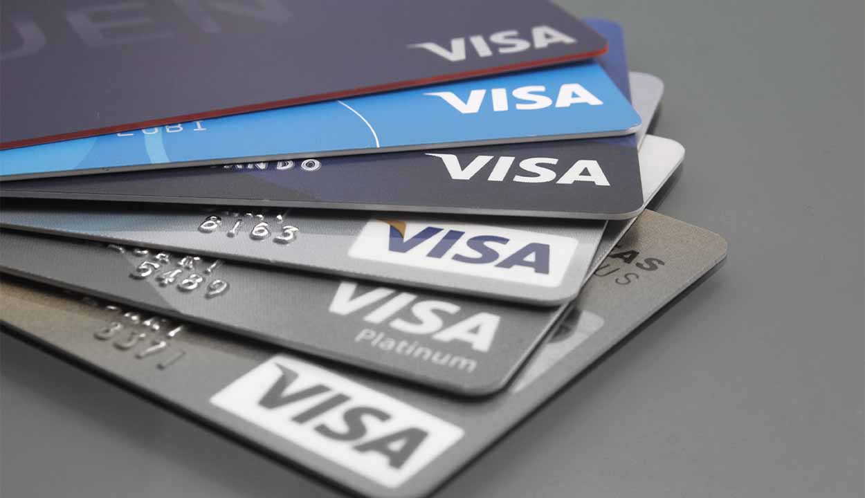 Vários cartões de crédito Visa sobre um fundo cinza.