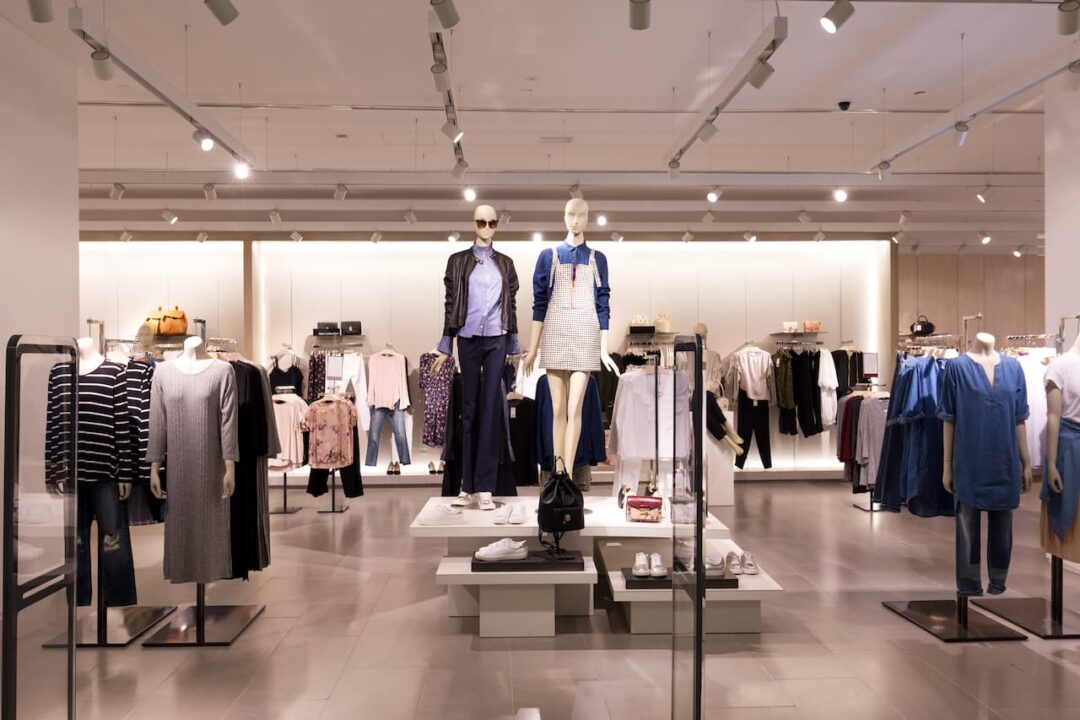 Interior de loja de roupas, com manequins e araras