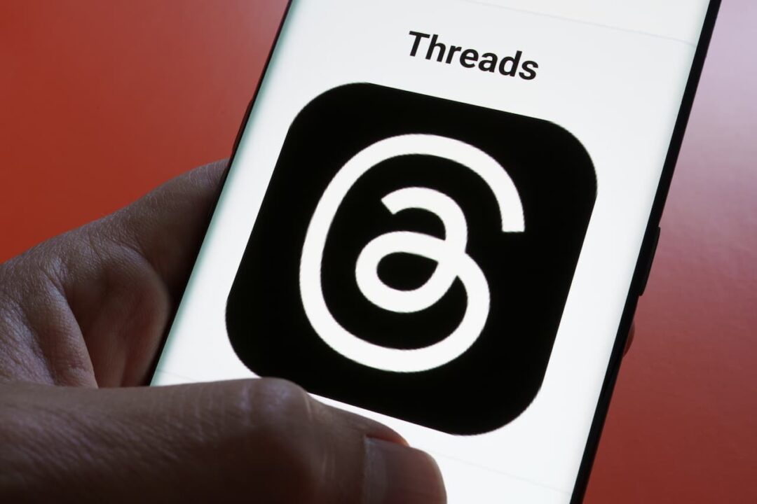 mão segurando celular com aplicativo Threads
