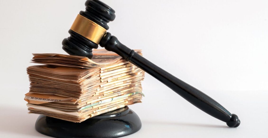 Martelo símbolo da Justiça sob um monte de dinheiro simbolizando herança.