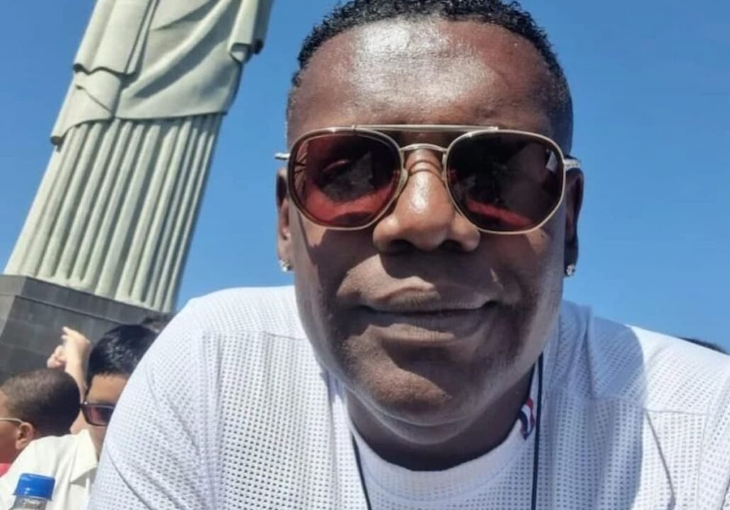 Imagem do funkeiro Mc Marcinho sorrindo em frente ao cristo redentor