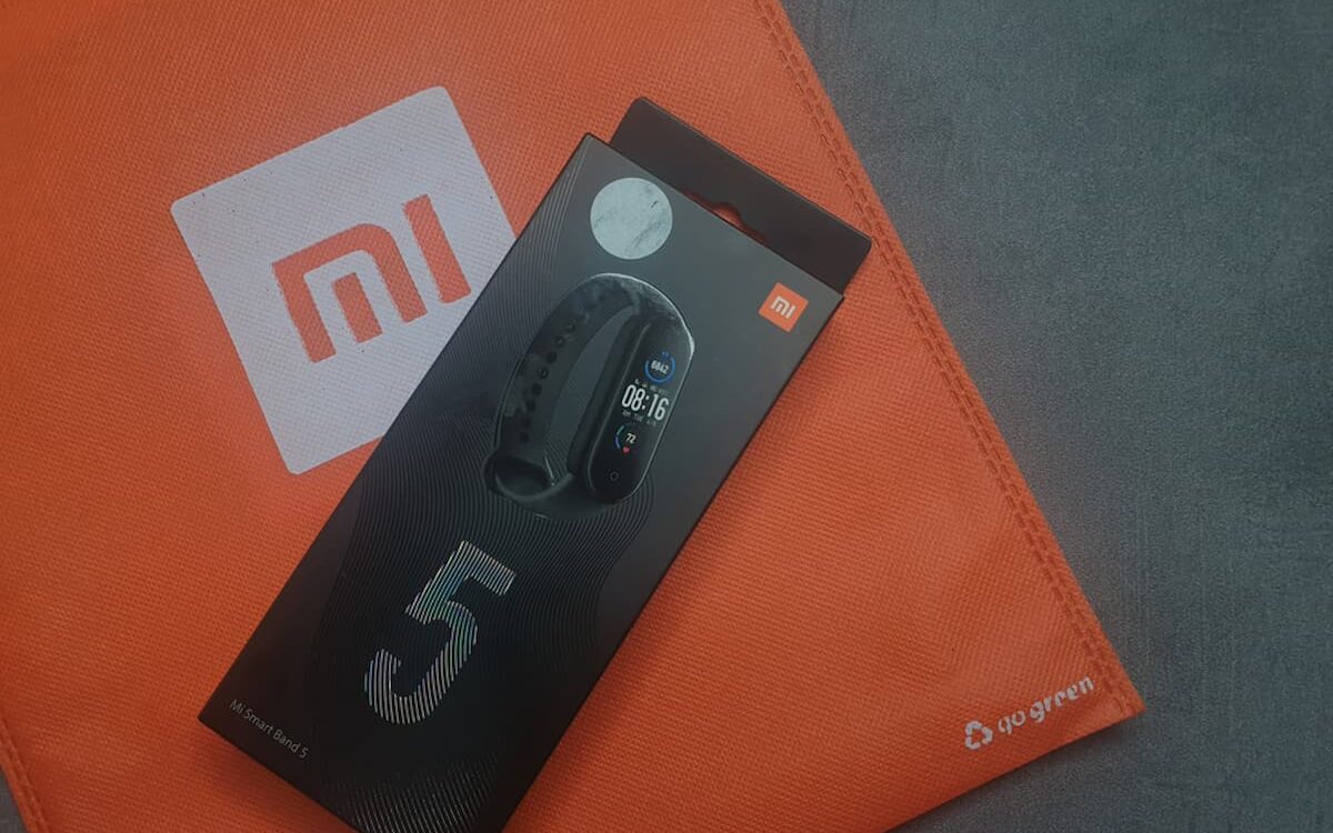 Imagem do smatwatch miband 5 da Xiaomi, em cima de uma embalagem da empresa.