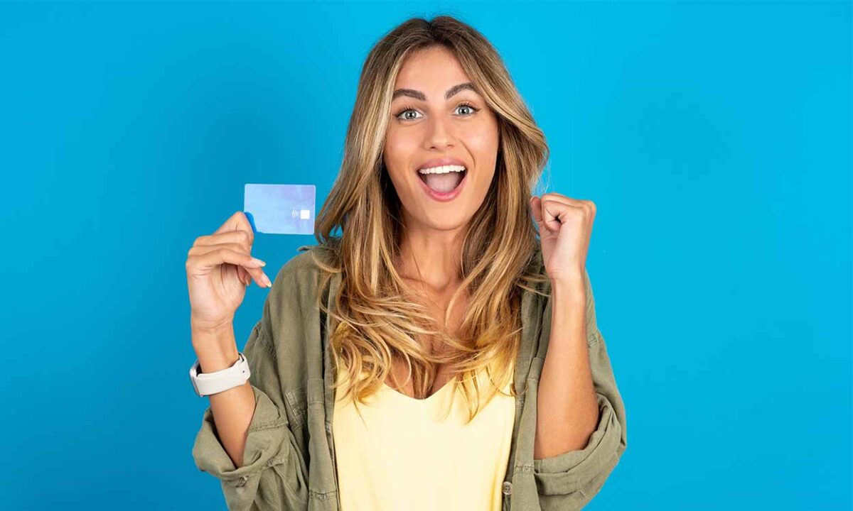 Mulher feliz segurando um cartão de crédito.