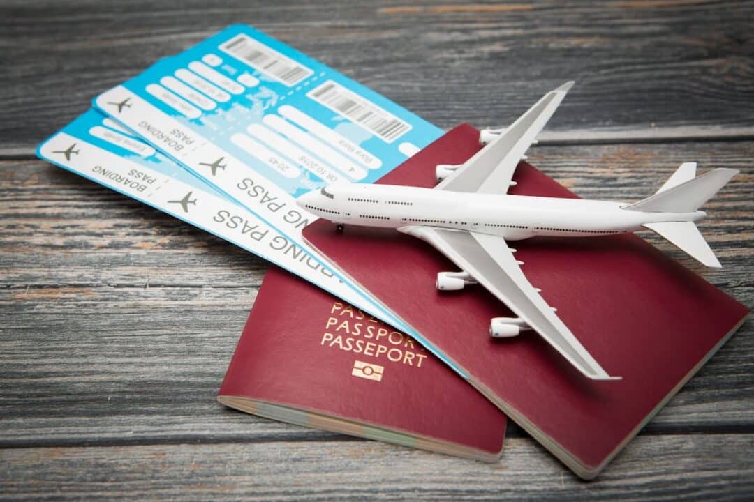 Passagem de avião dentro de passaporte com avião miniatura sobre o mesmo