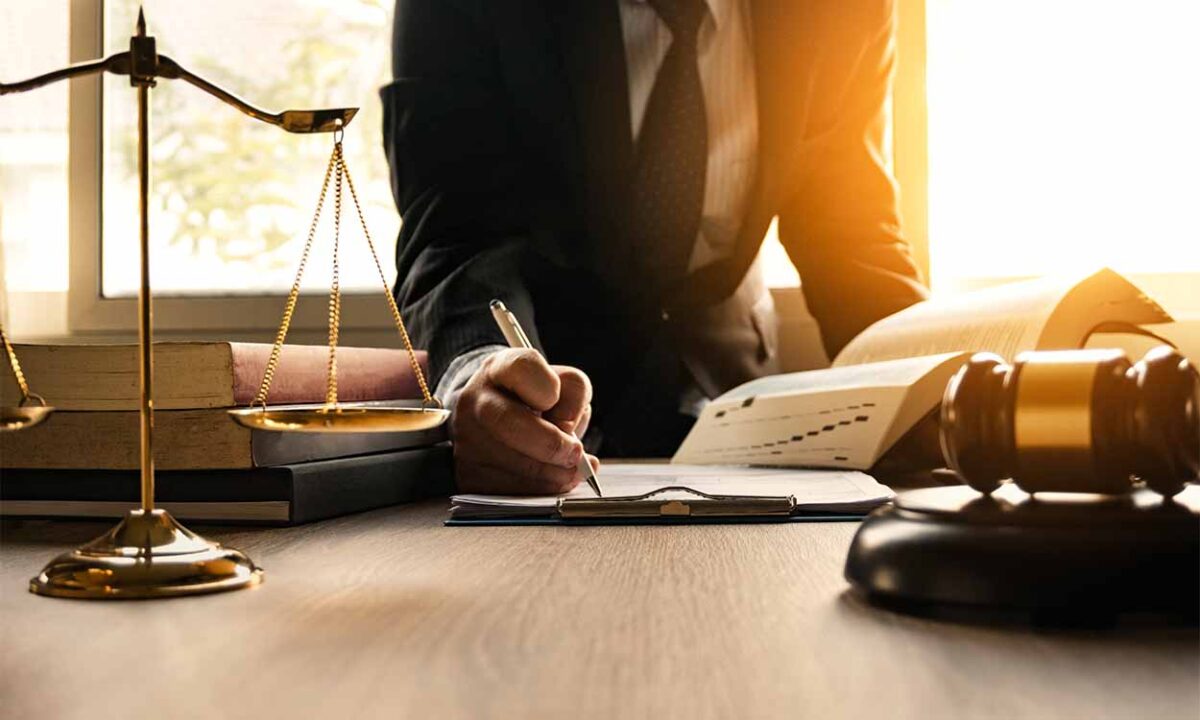 Pessoa de terno assinando um papel em um escritório judiciário