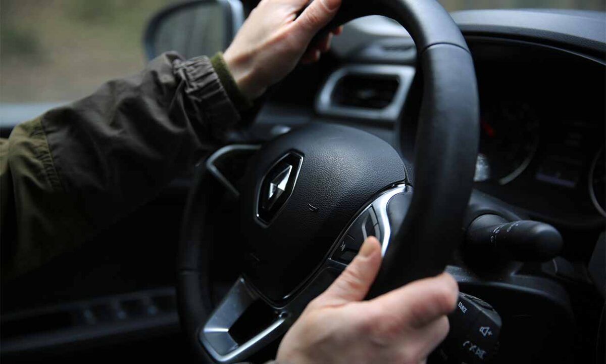 Imagem de homem segurando o volante de um veículo da Renault.
