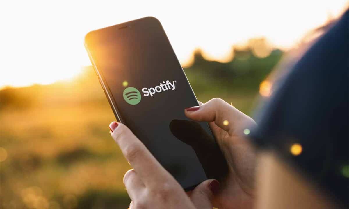 Pessoa segurando celular com o logo do Spotify na tela
