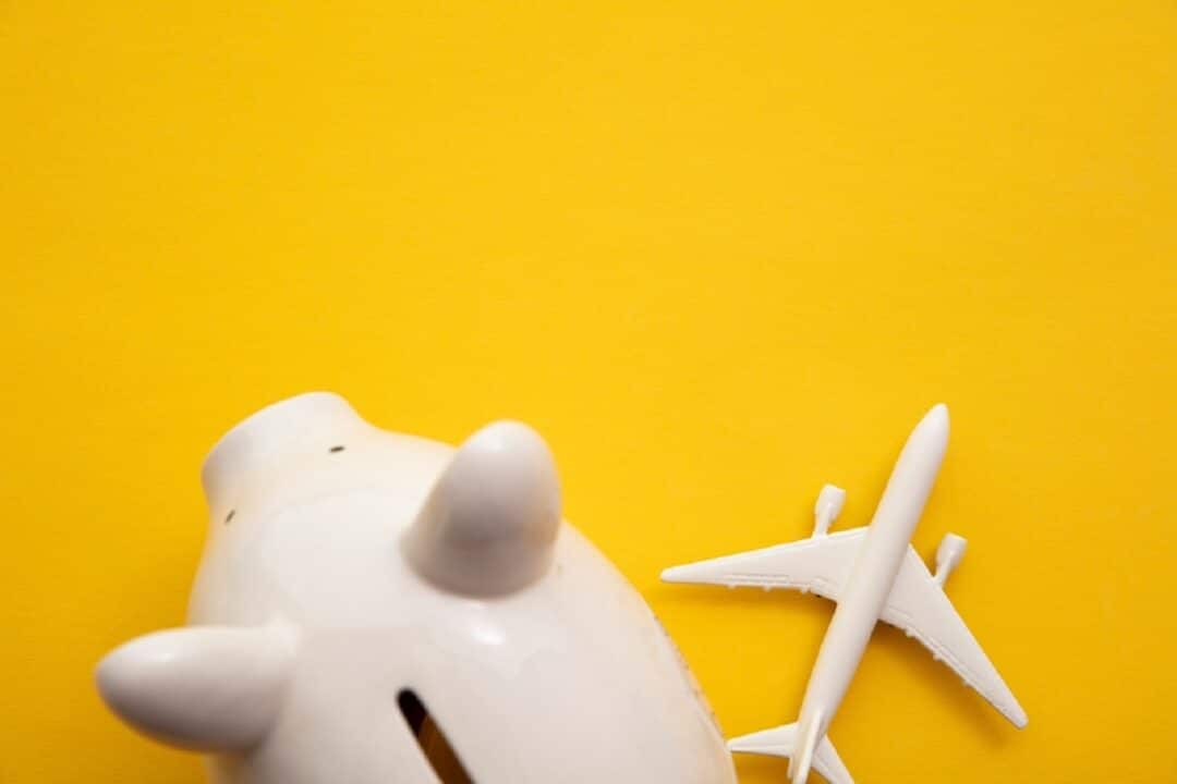 Imagem de um cofre em formato de porco e um avião em miniatura Gol, Azul