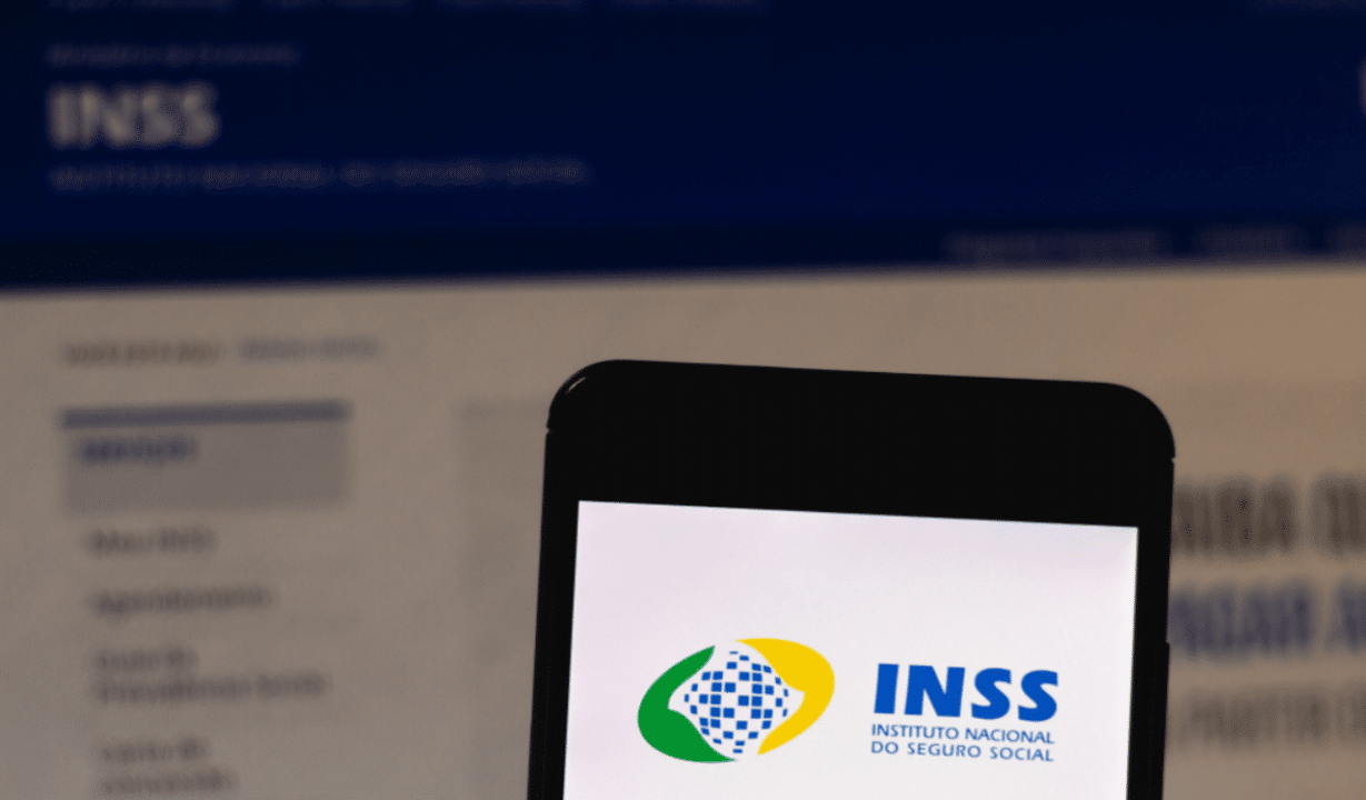 Tela de celular com app INSS e site do Instituto aberto no fundo