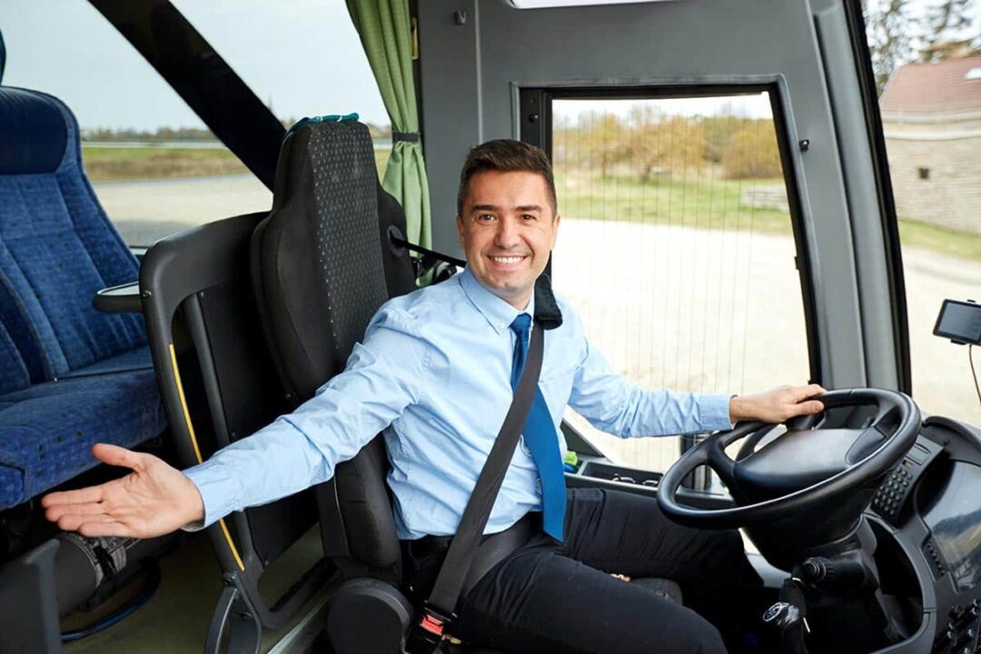 motorista de ônibus sorri enquanto abre o braço para receber passageiro