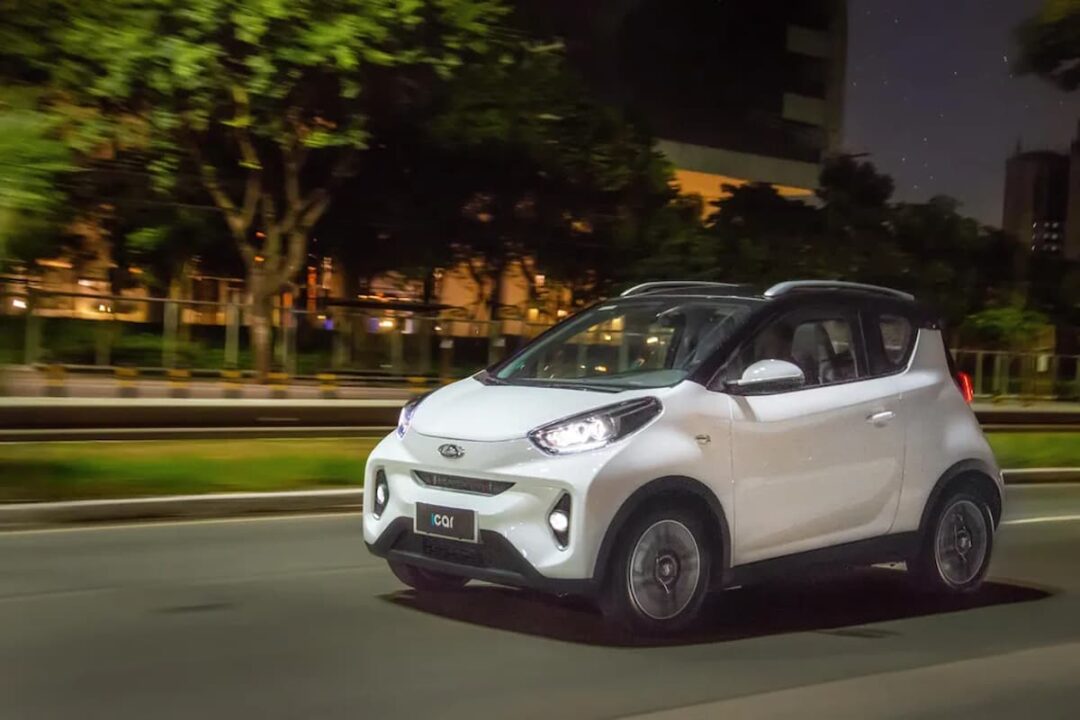 Imagem do novo veículo elétrico da Caoa Chery, o iCar, andando na rua, em sua cor branca.