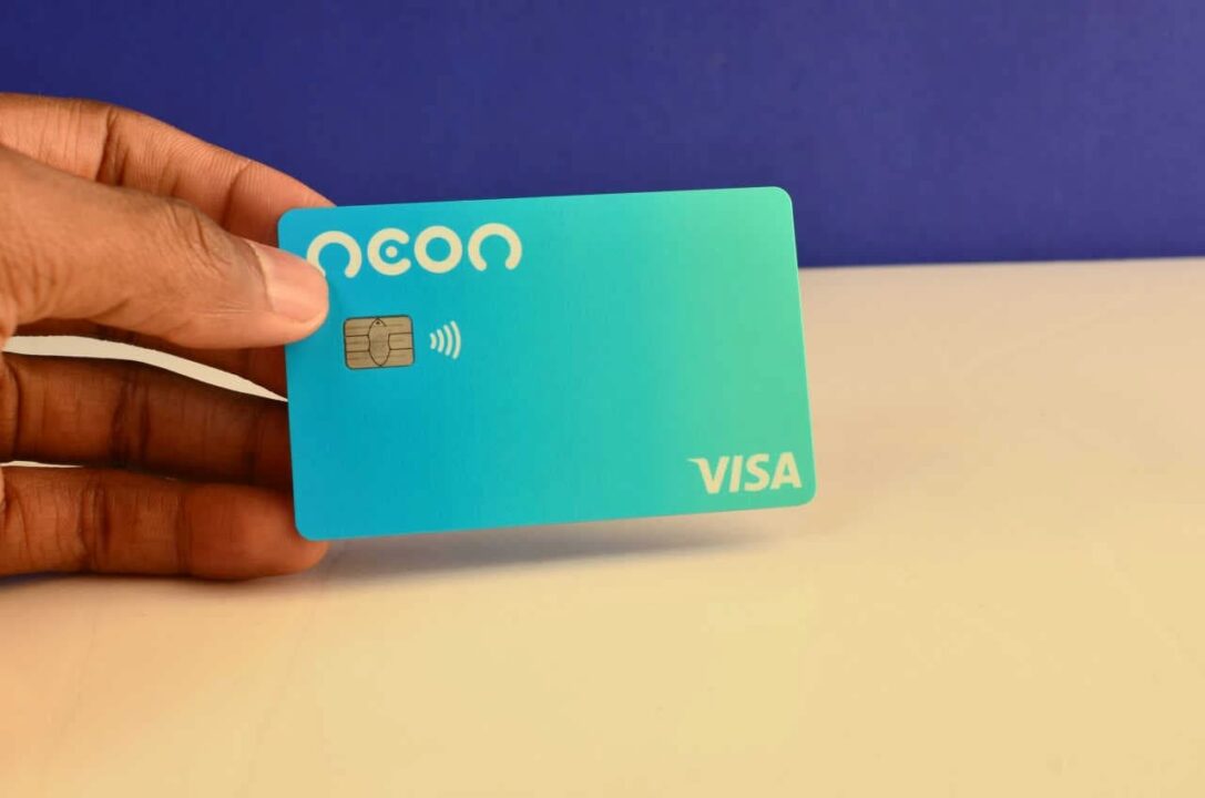 Mão segurando um cartão de crédito da Neon