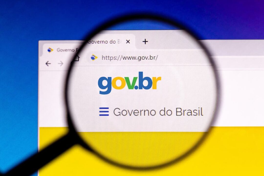 A imagem mostra o site do Gov.br aberto e uma lupa no nome "gov.br", com letras em azul, amarelo e verde.