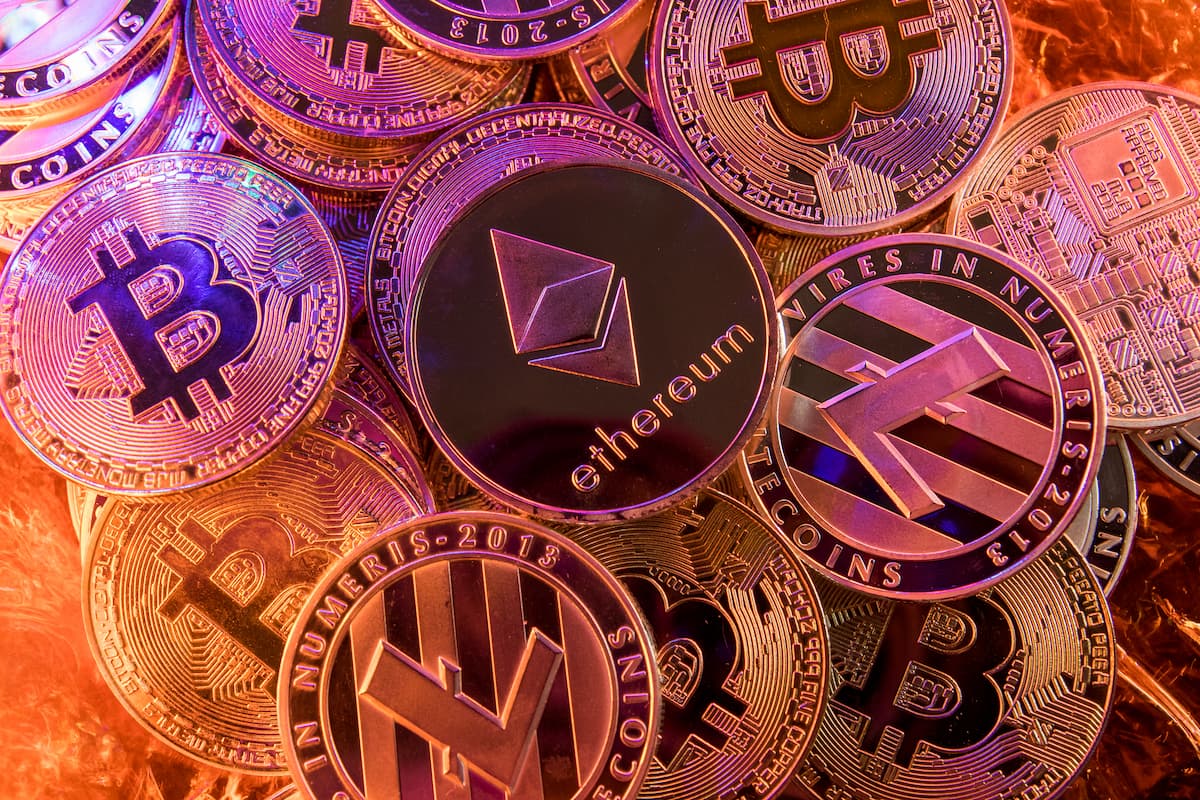 Criptomoedas empilhadas sobre mesa com diversos nomes